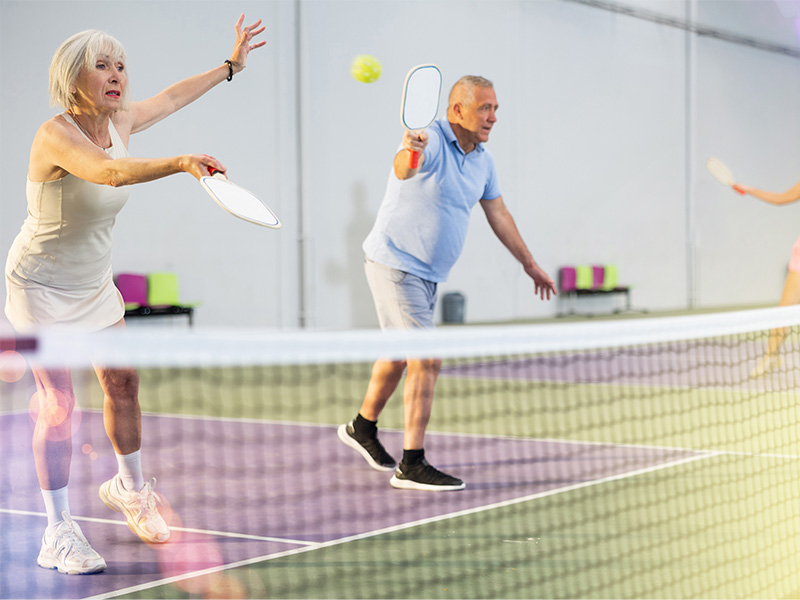 Older couple playing pickle ball