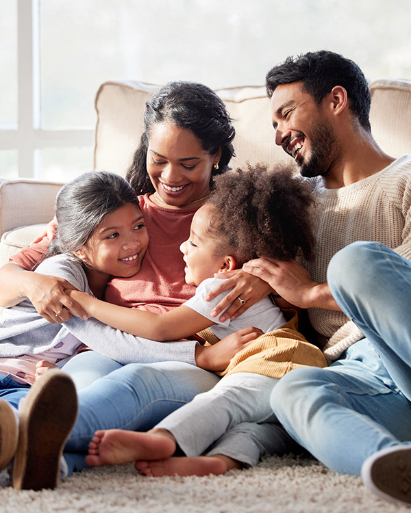 Family sitting on floor hugging and laughing