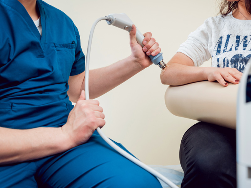 Patient getting shockwave therapy treatment on their elbow