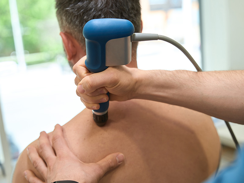 Patient getting shockwave therapy treatment on their back